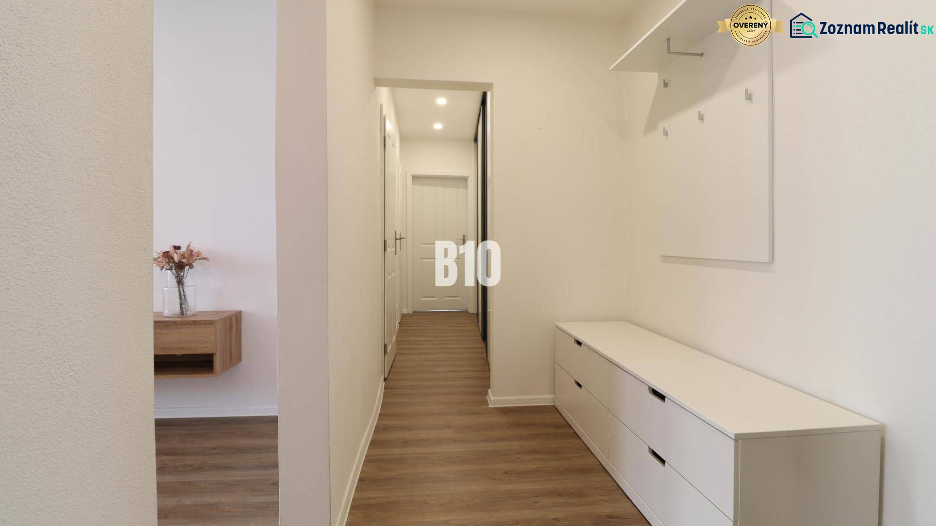 Hallway of a 3-room apartment with a wooden decor floor and storage spaces.
