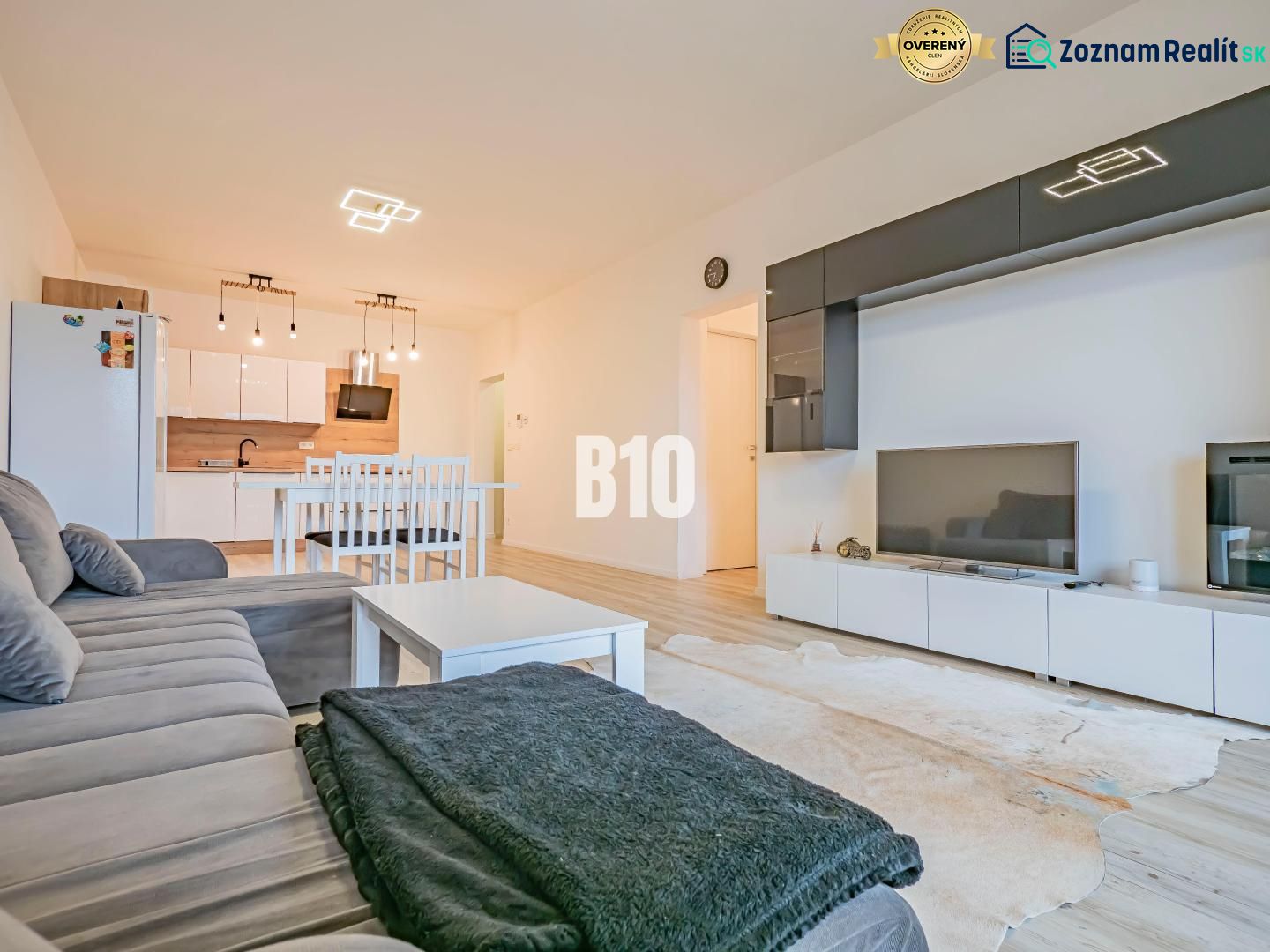 Living room with kitchen, white furniture, sofa and floor with wood decor.
