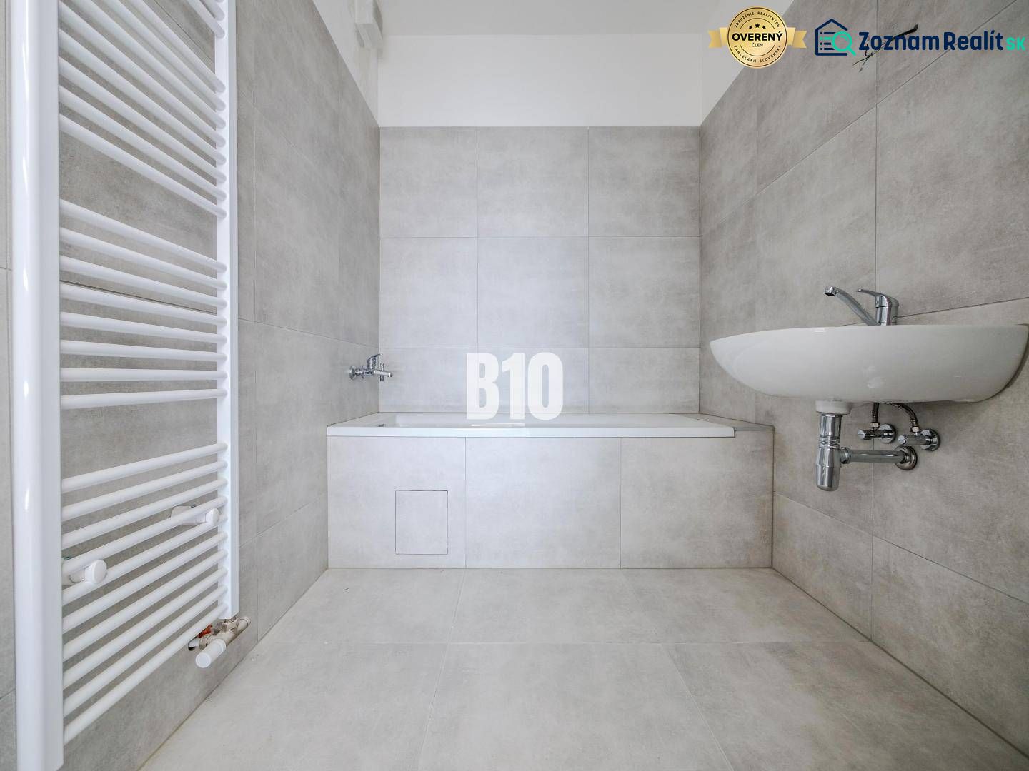 Bathroom with a bathtub and a sink in a 3-room apartment with modern tiles.