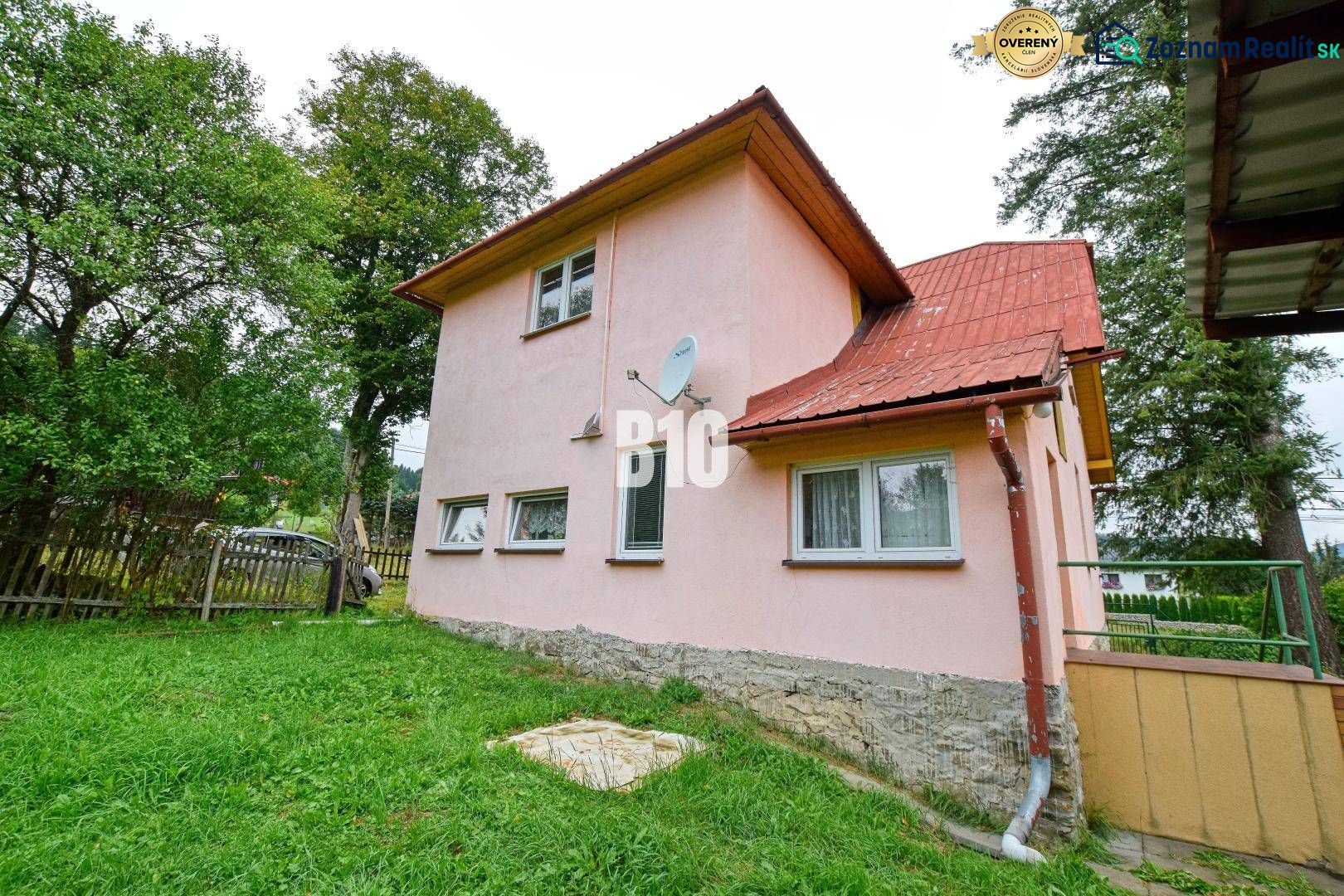 A family house in Makov with a pink facade, a garden, and a satellite dish on the wall.