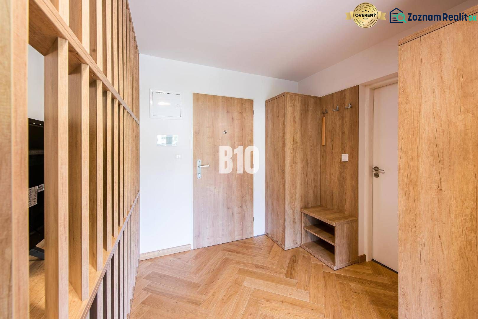 Entrance hall in a one-room apartment with wood-patterned flooring and furniture.