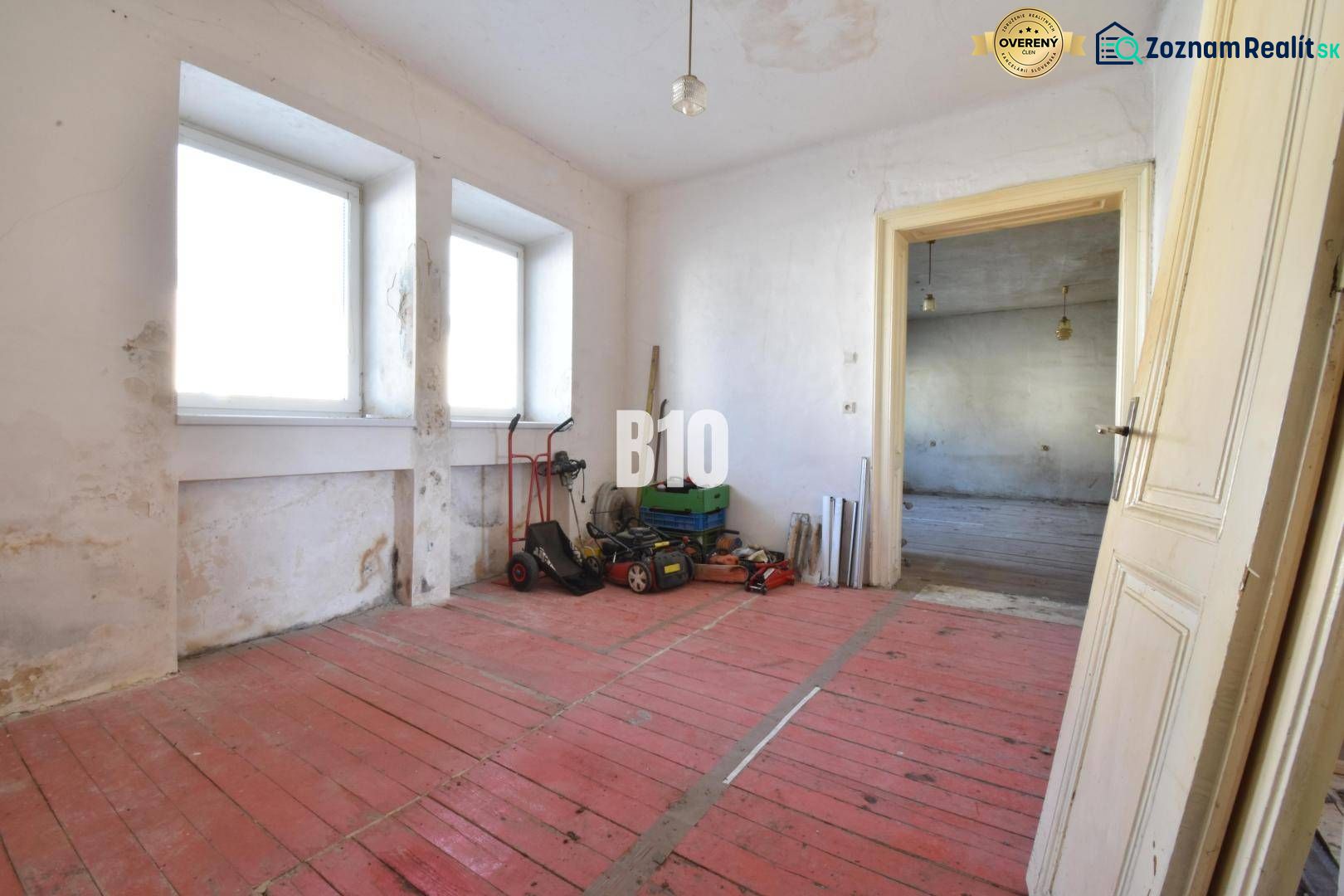A room in a family house with a red floor and windows, Bytča.