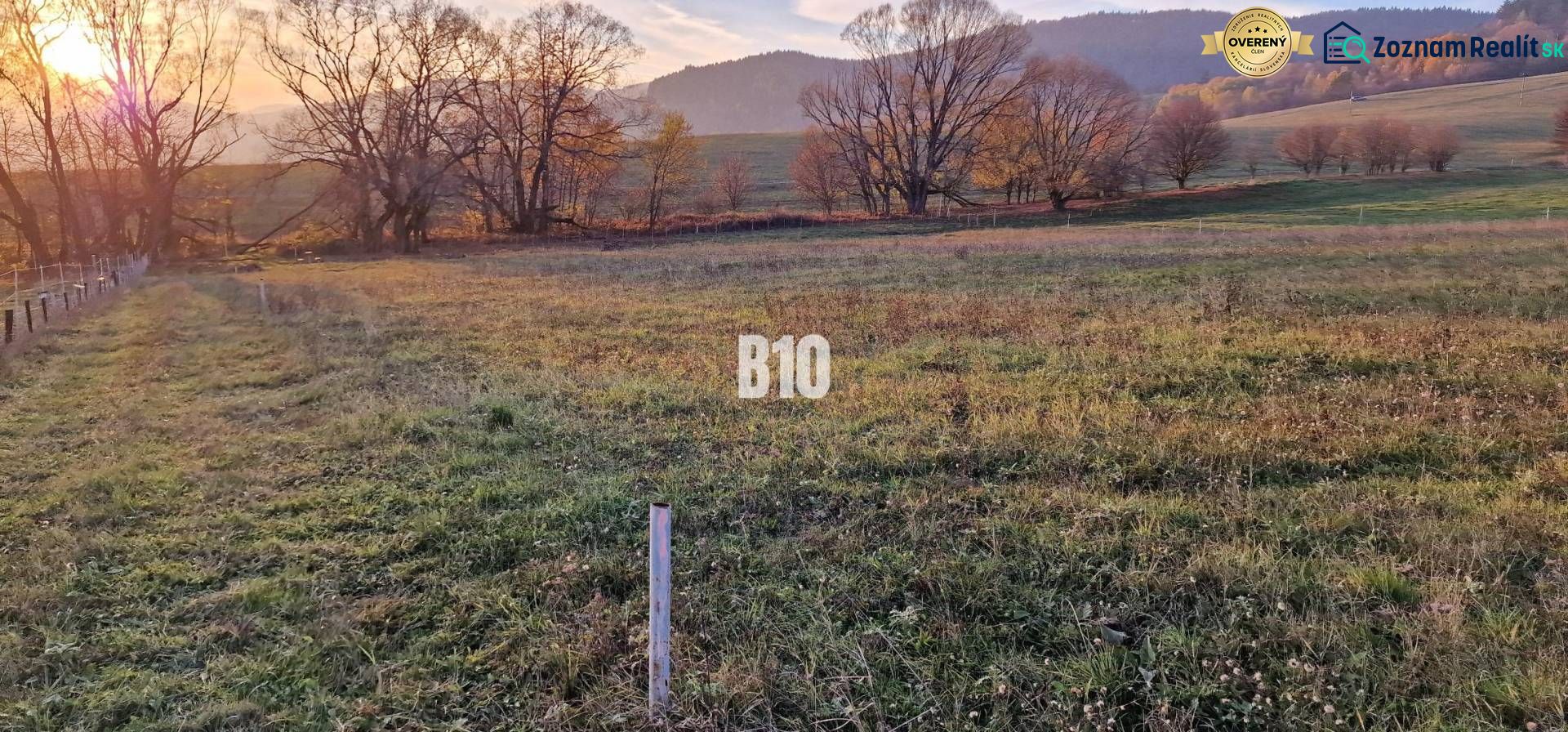 Sunset over green fields surrounded by trees and mountains, ideal for plots - housing.
