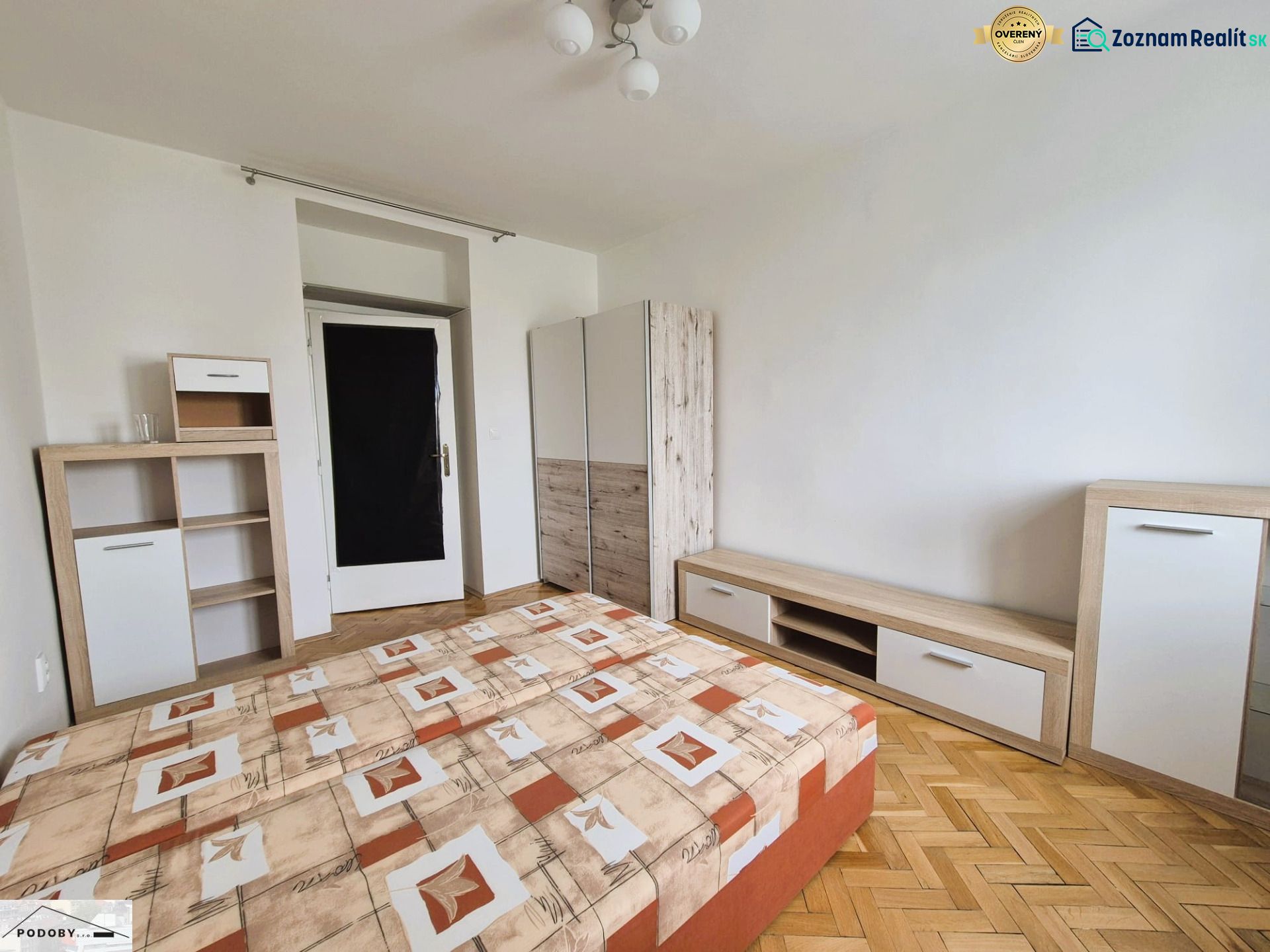 A bedroom with a bed, storage furniture, and a wooden decor floor in a 3-room apartment.