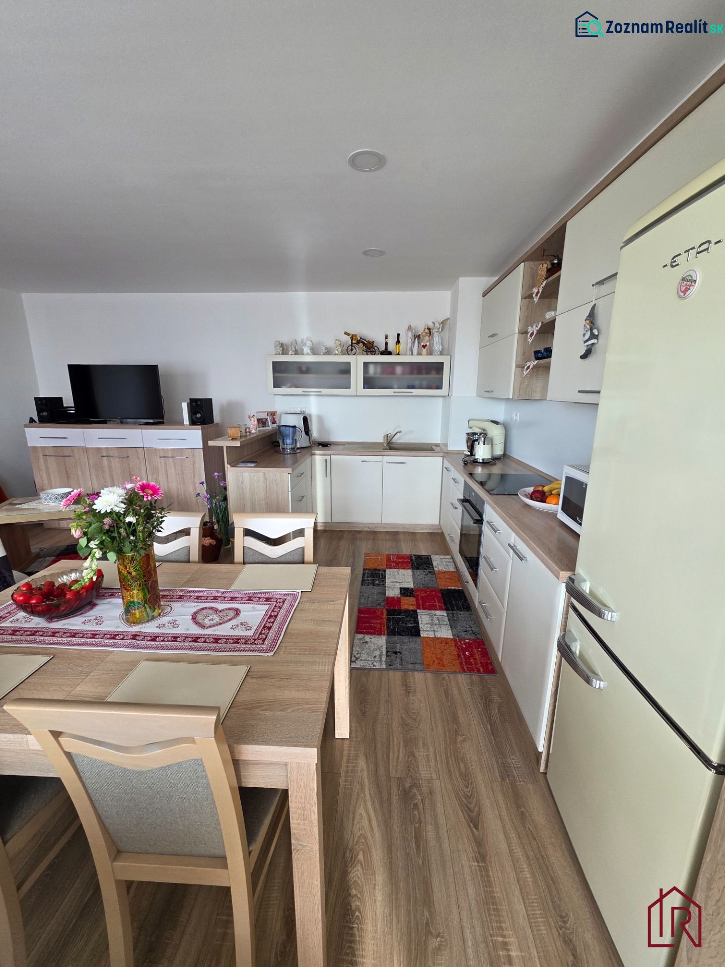 A kitchen in a 3-room apartment with a wooden decor floor, a dining table, and furnishings.