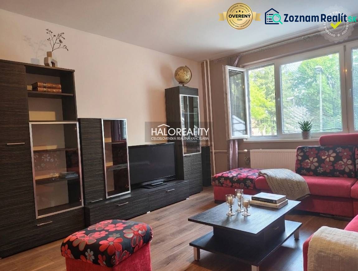 A living room in a three-room apartment with a wooden decor floor and vibrant colored furniture.