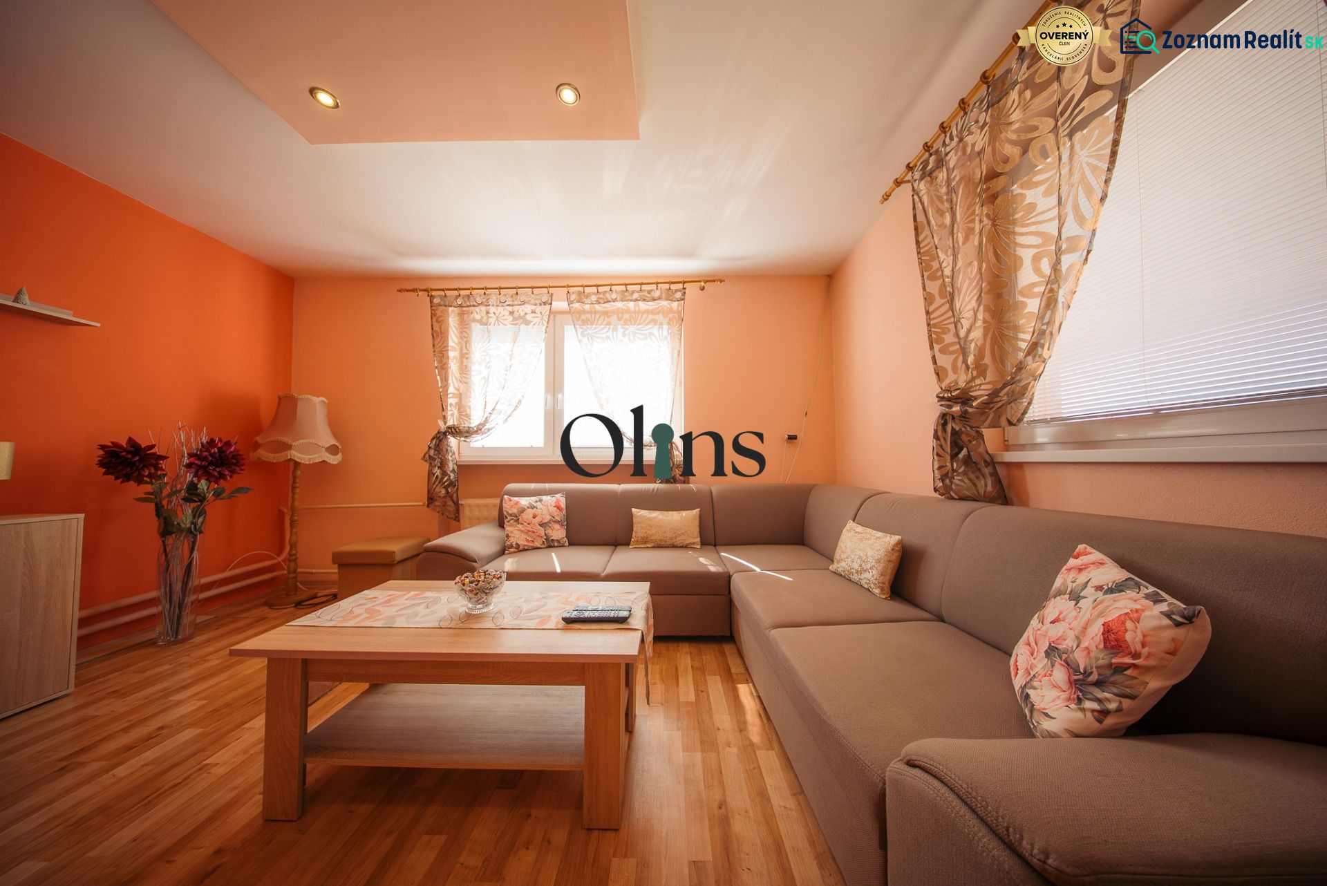 Living room in a family house with orange walls, a comfortable sofa, and decorative pillows.
