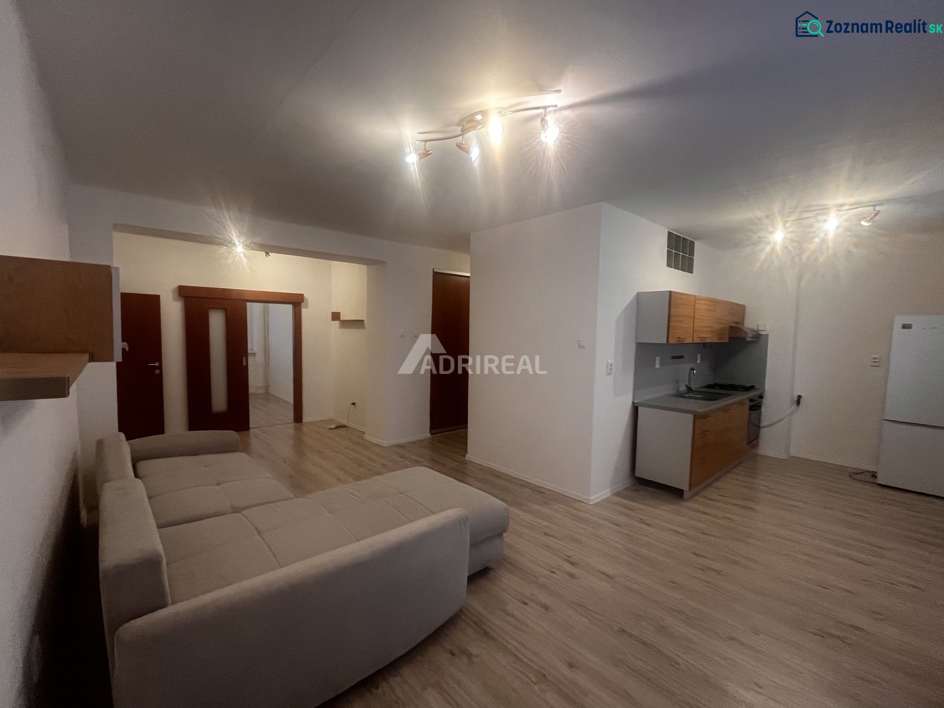 Living room in a 3-room apartment with a kitchen and a floor with a wooden decor.