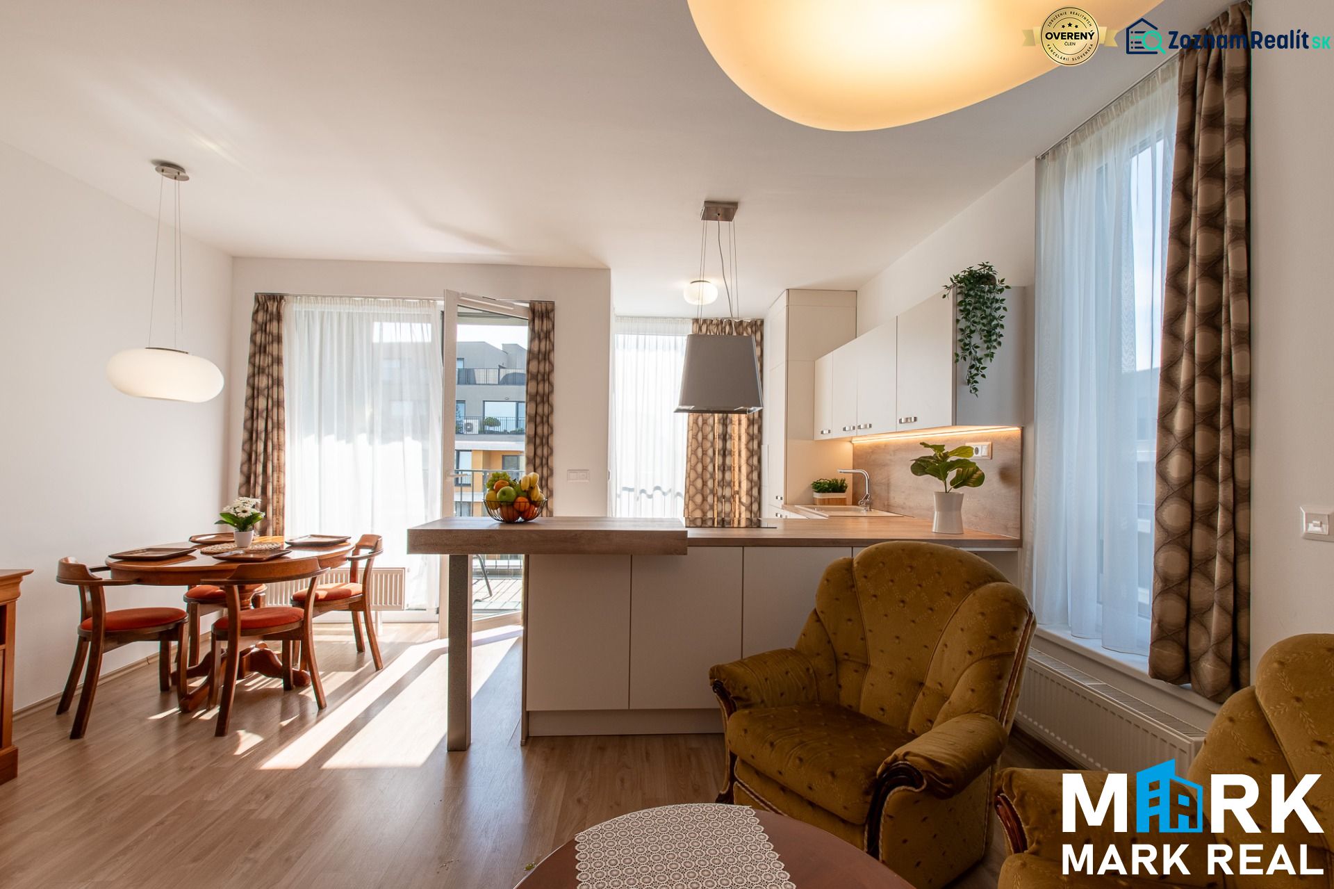 Living room connected with kitchen, dining table, wooden decor flooring, light curtains.
