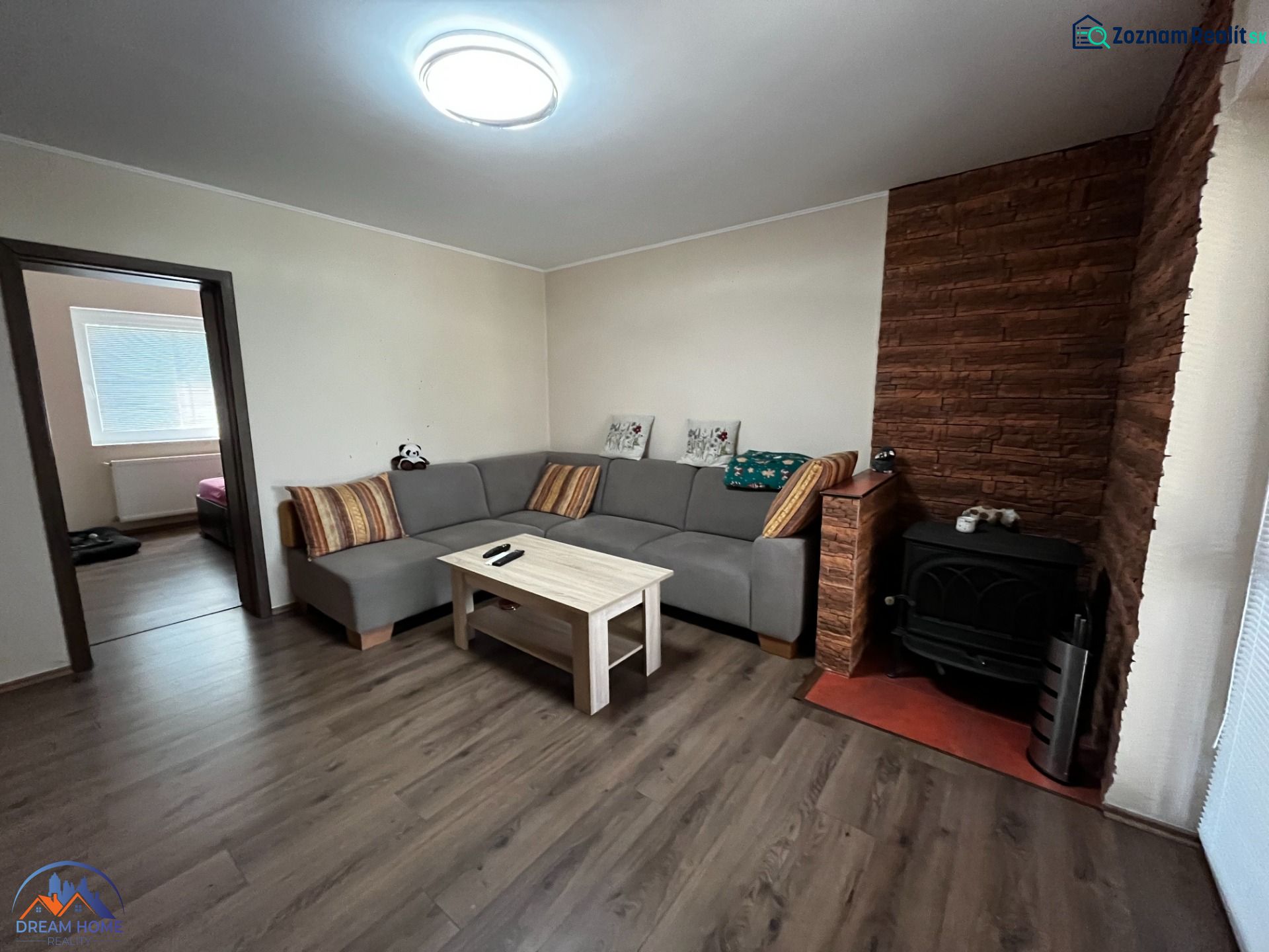 Living room in a family house with a wooden decor floor and a tiled stove.