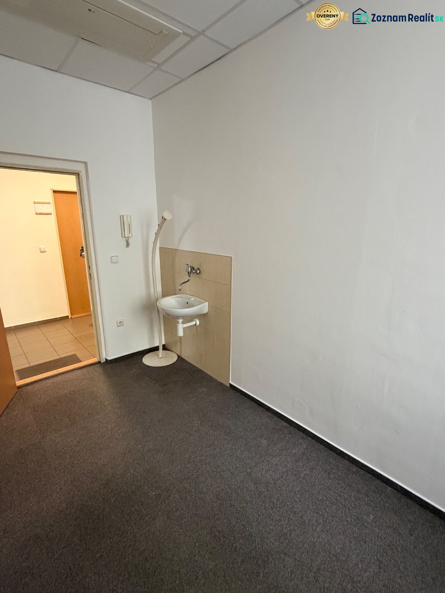 Offices with carpet, sink, and white walls.