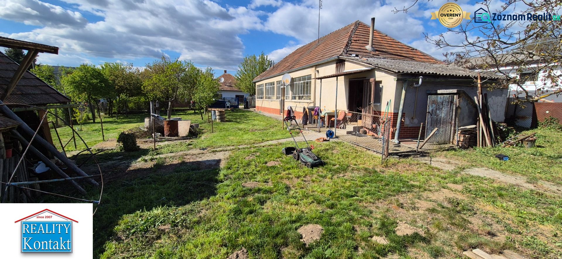 No Village: Family house with a garden and an annex, with a lawnmower on the lawn.