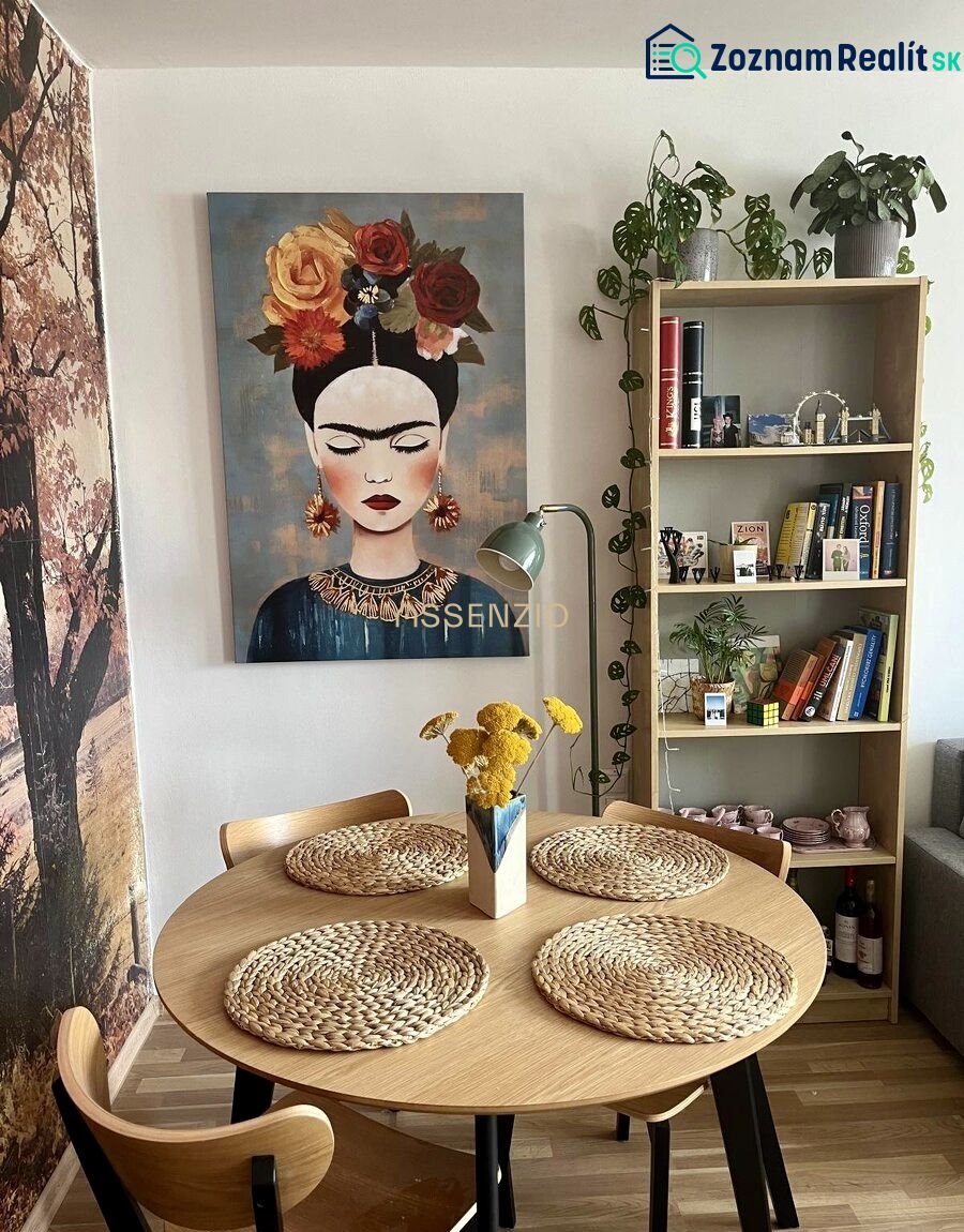 Dining room in a 2-room apartment with a painting, wooden table, and decorative accessories.