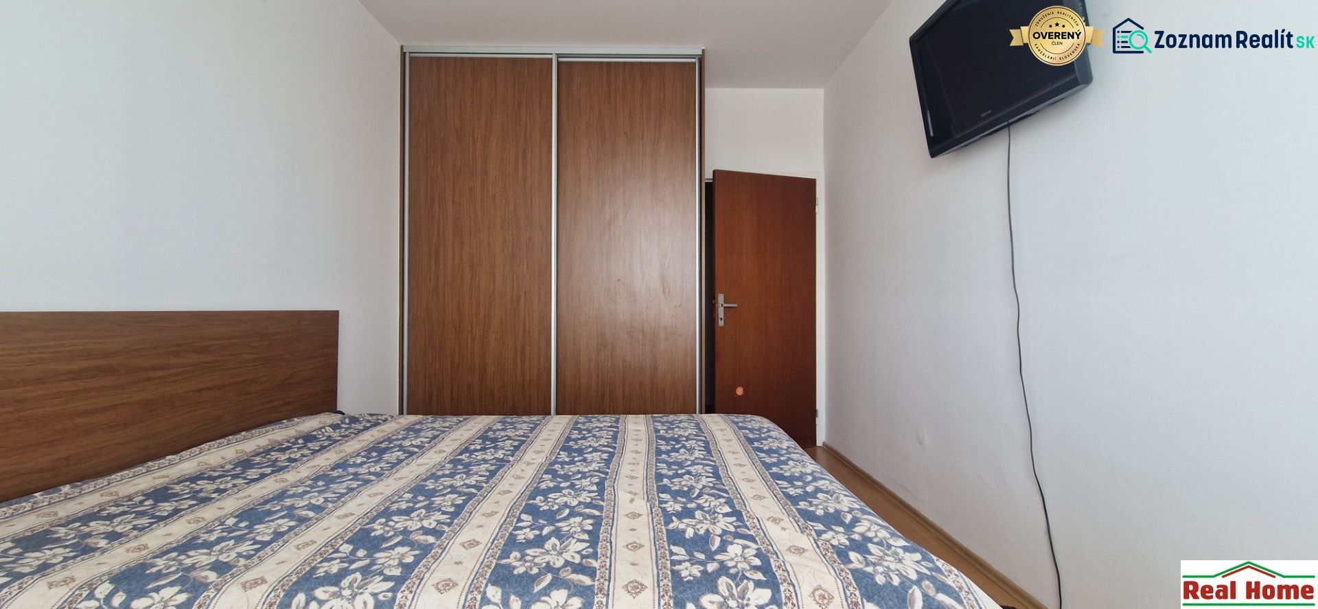 A bedroom with a large built-in wardrobe in a 2-room apartment.