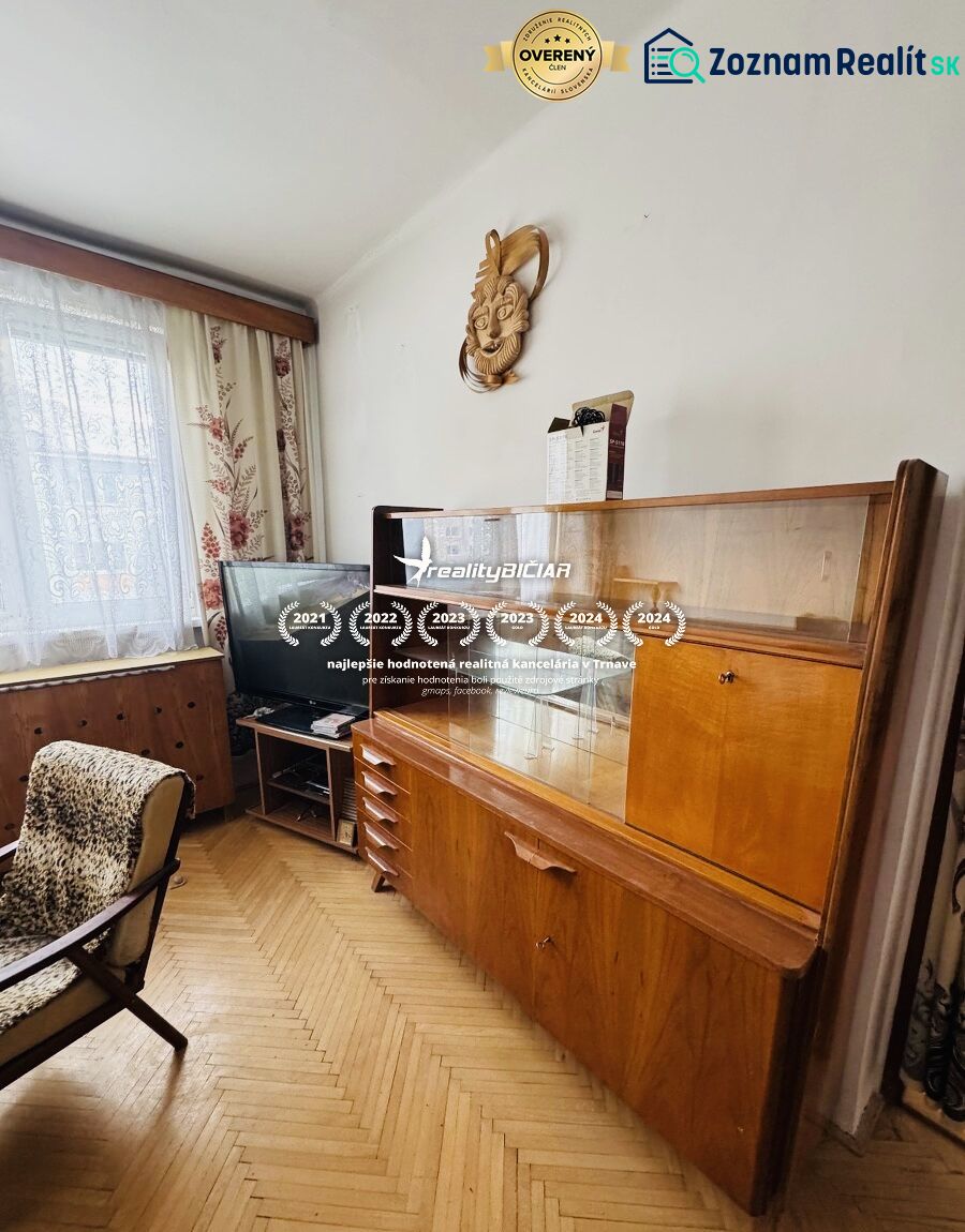 A view into a living room with retro furniture and a wooden decor floor in a 3-room apartment.