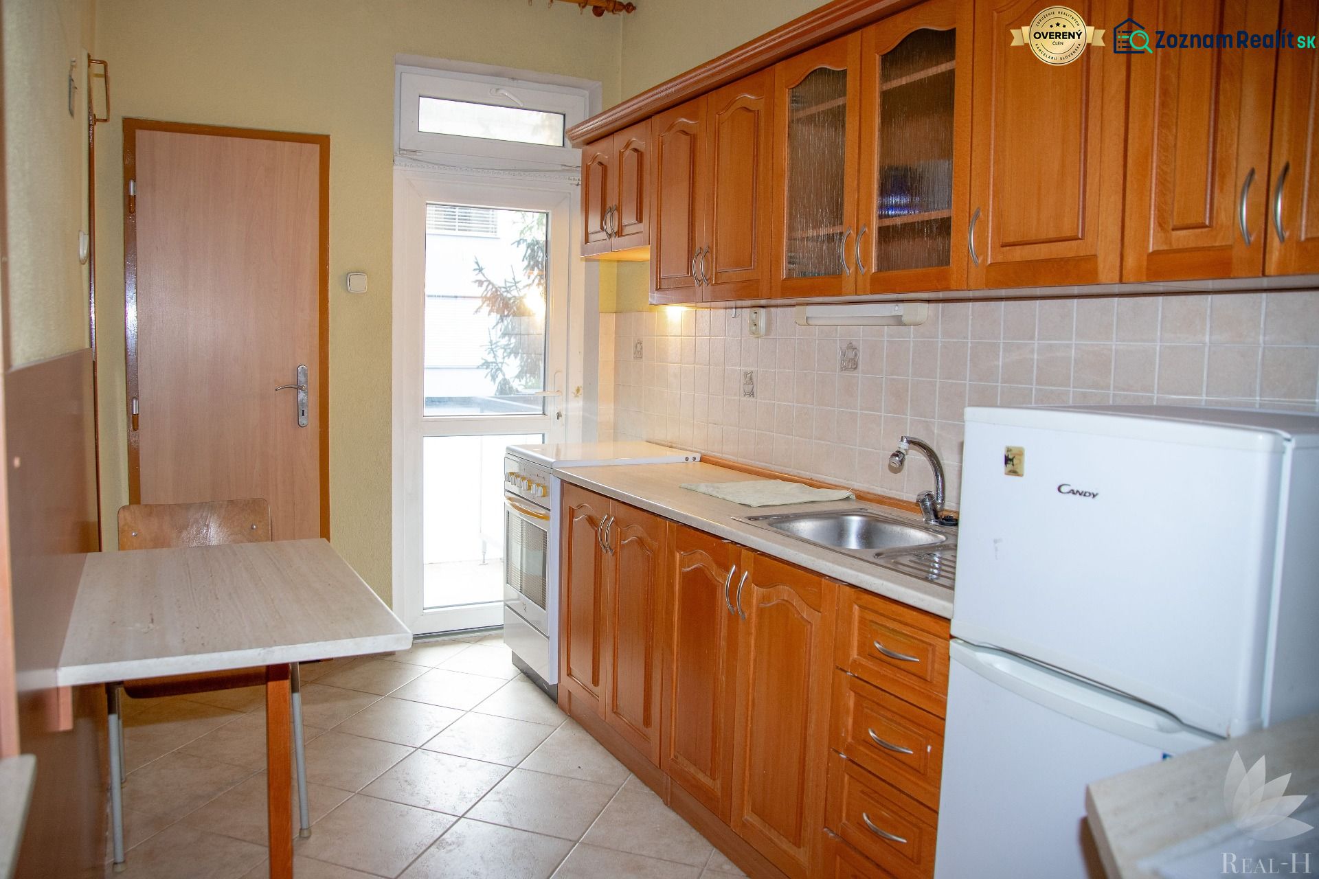A kitchen with wooden cabinets and a table in a 2-room apartment.