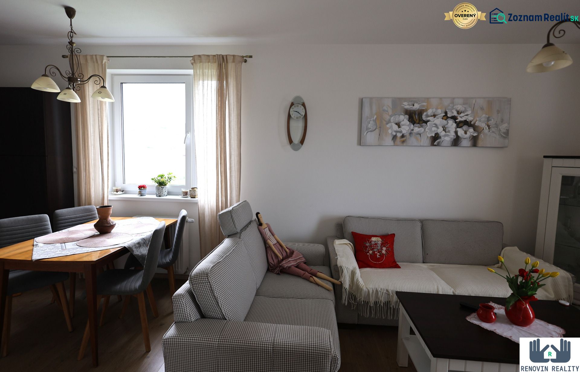 Living room of a two-room apartment with a sofa, table, decorations, and a floor with a wooden design.