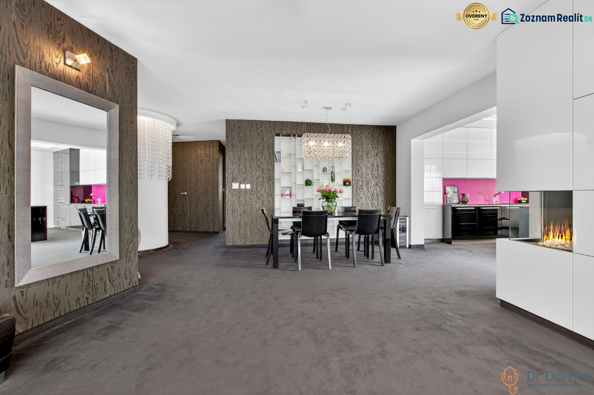 Dining room in a 4-room apartment with a mirror, fireplace, and kitchen with pink tiles.
