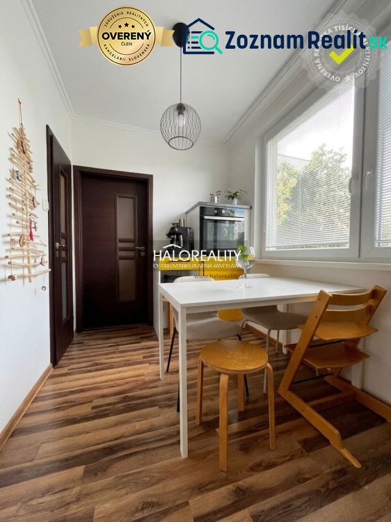 A kitchen in a 3-room apartment with a white table and a wooden decor floor.