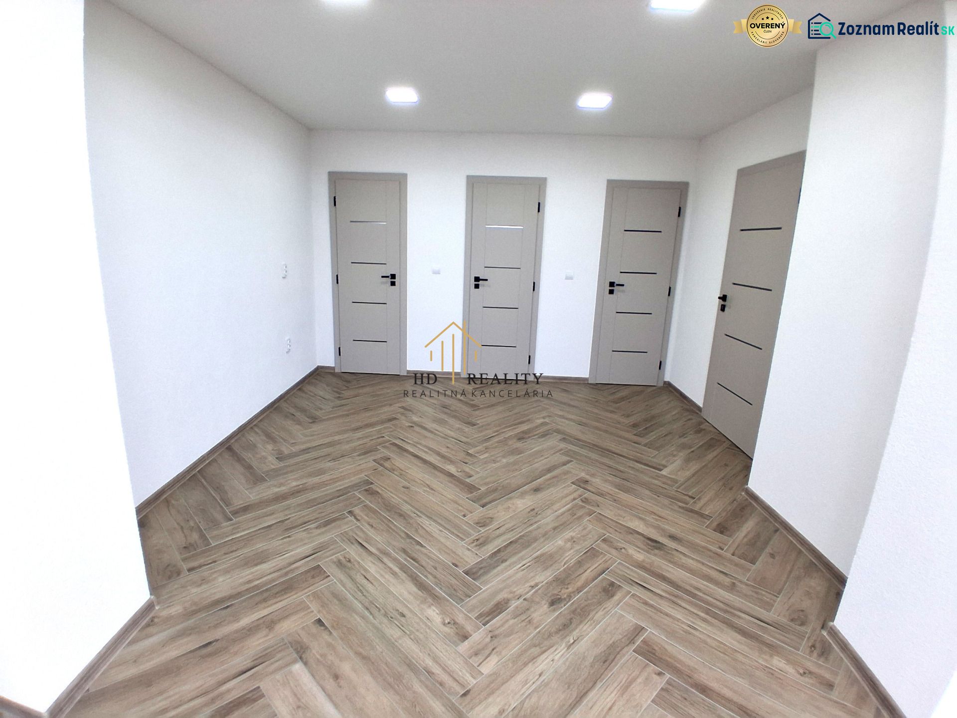 Interior of commercial premises with three doors and a wooden decor floor.