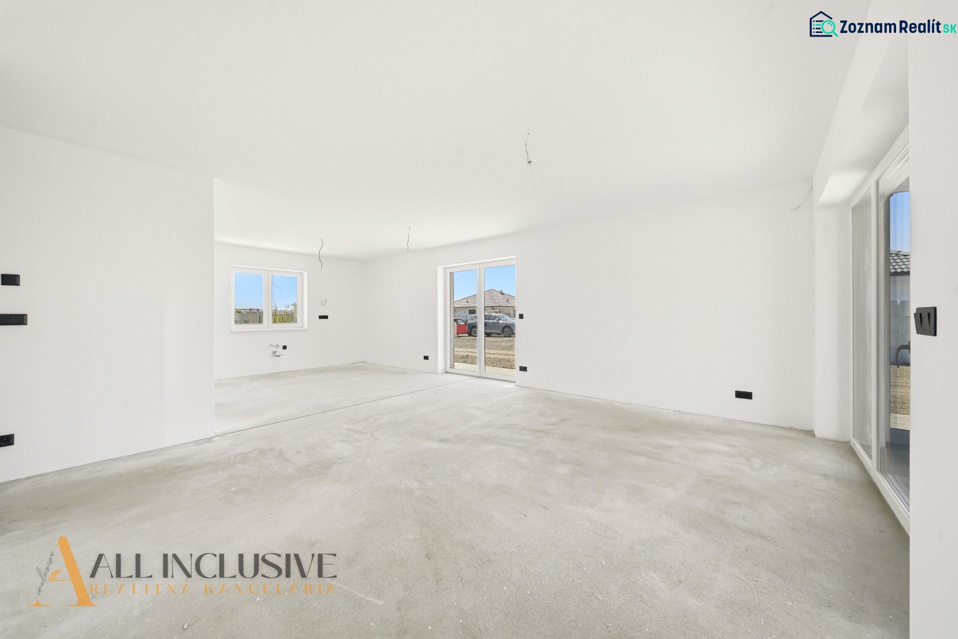 Spacious room with white walls and an empty floor, living area of a family house.