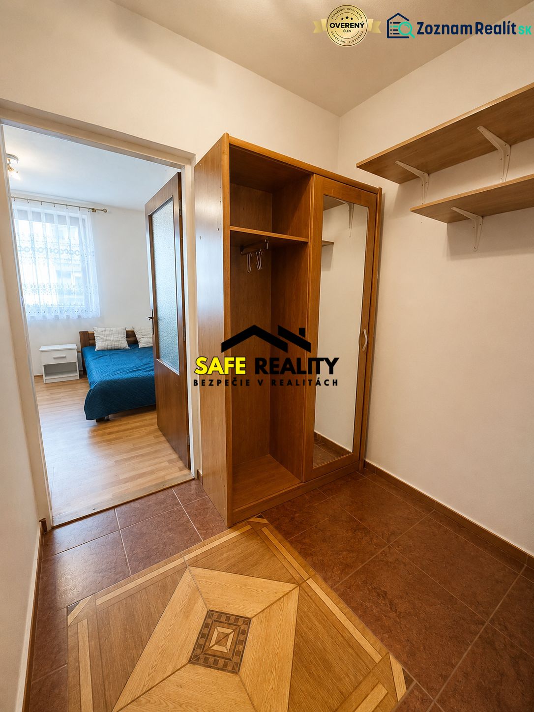 Studio apartment with wood-patterned flooring, built-in wardrobe, and a bed in the background.