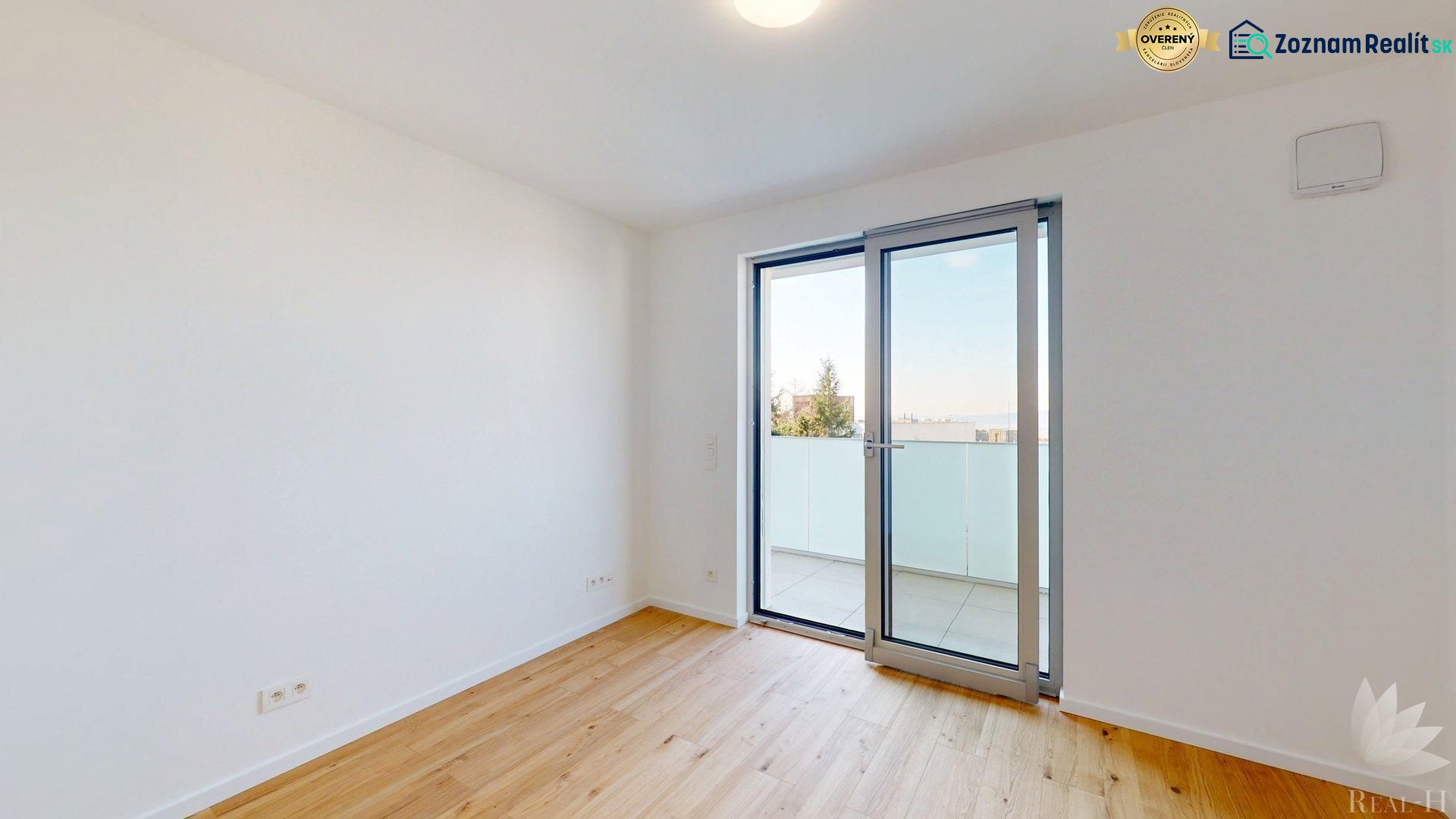 An empty room with a wooden floor decor and balcony doors in offices.