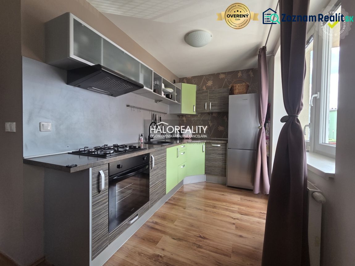 A kitchen in a 2-room apartment with a wood-patterned floor and modern appliances.