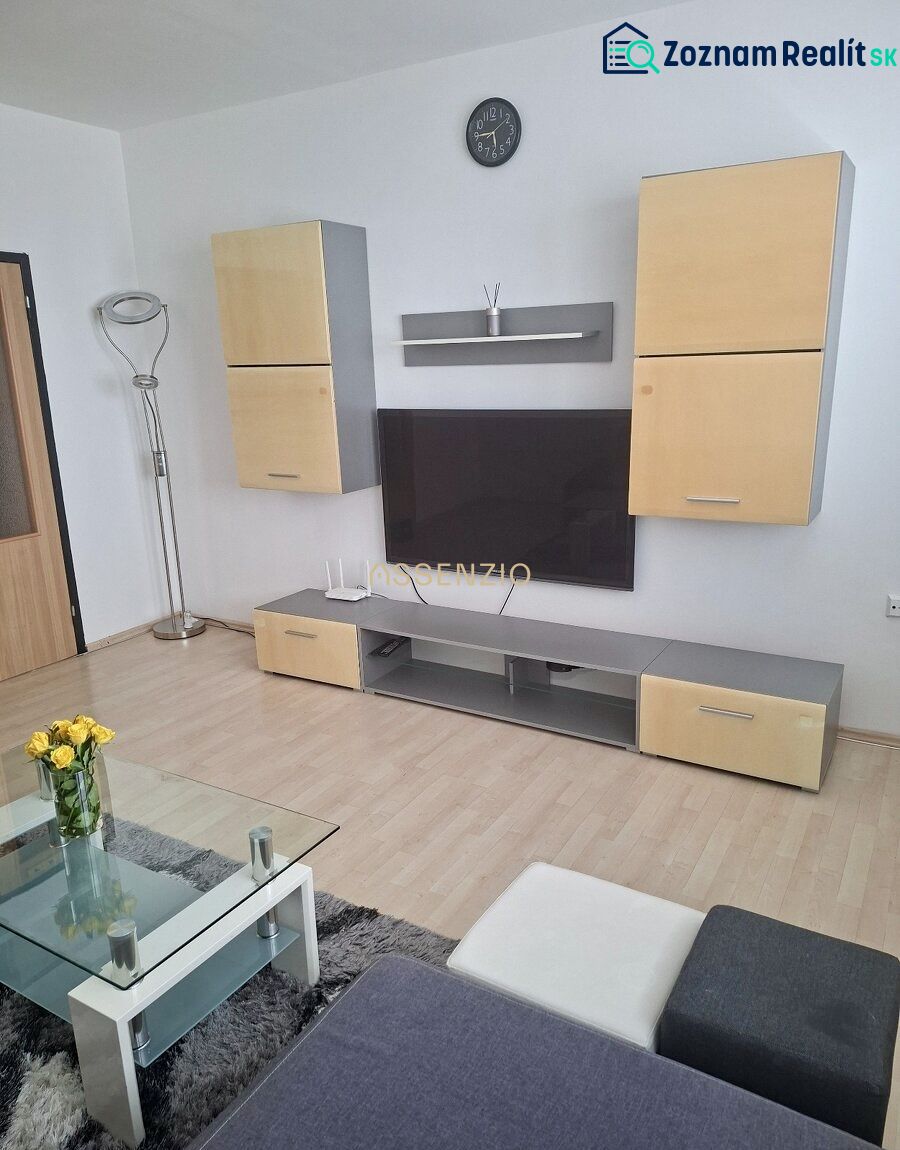 Living room with a TV, wooden decor flooring, a sofa, and a coffee table in a 3-room apartment.