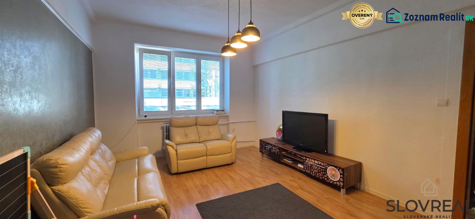 Living room in a 2-room apartment with a wooden decor floor and light furniture.
