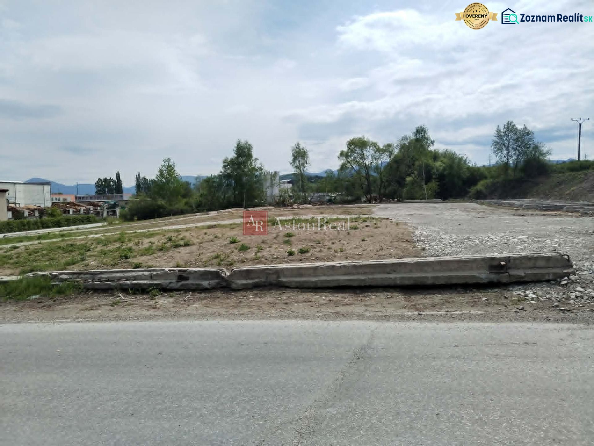 Commercial plots in Martin with an asphalt road and greenery in the background.