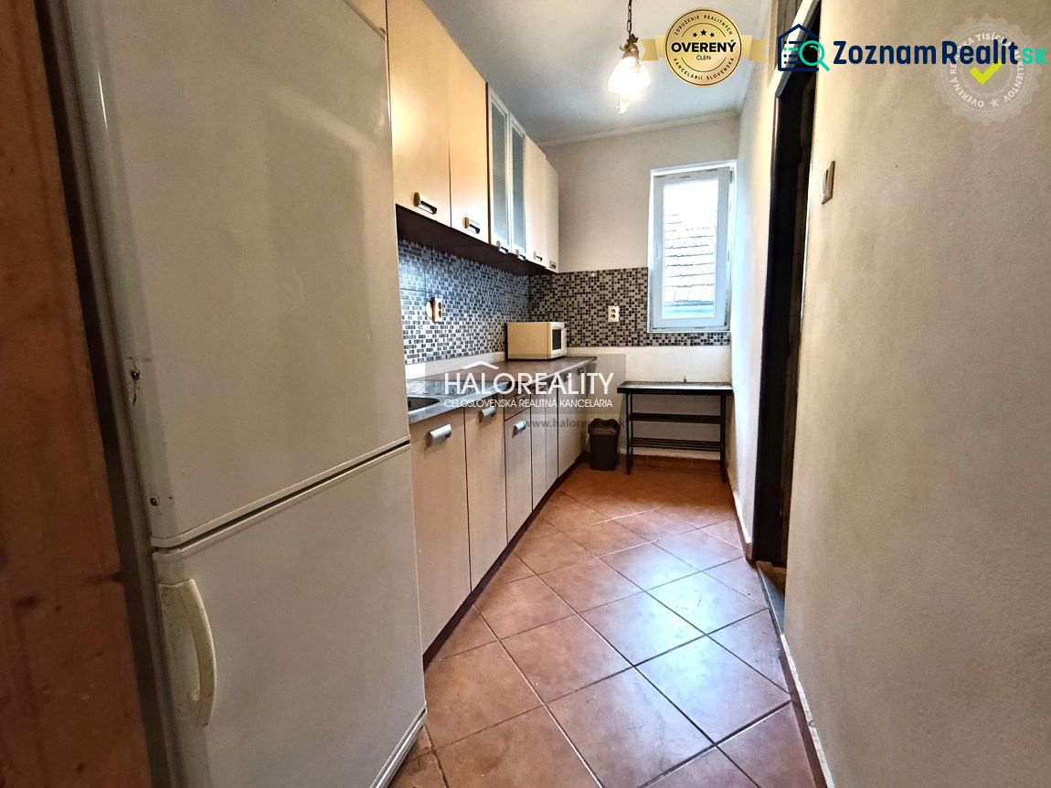 A kitchen in a 3-room apartment with tiles and a light cabinet.