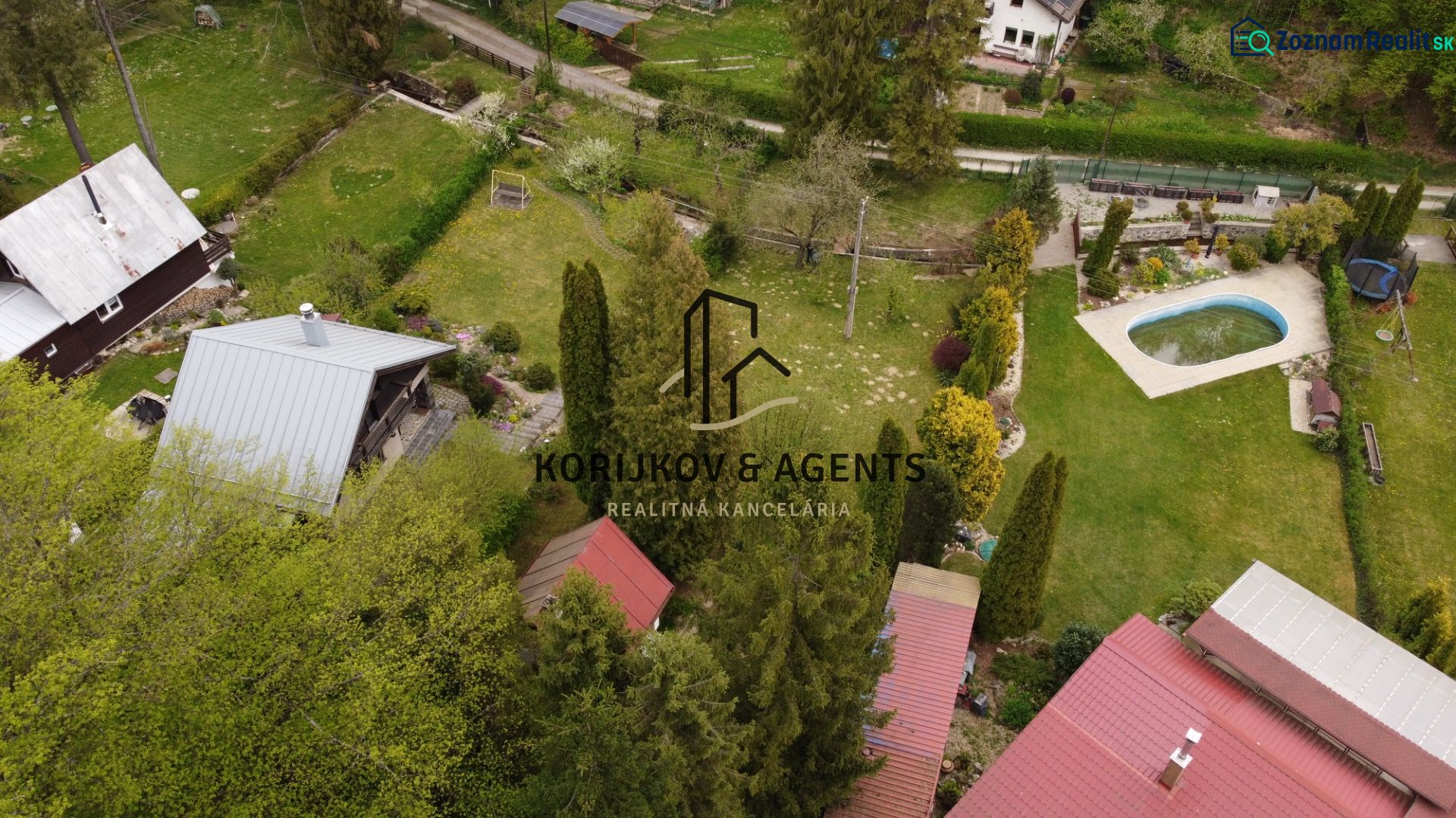 Aerial view of cottages in Nižný Klátov with a pool and gardens.