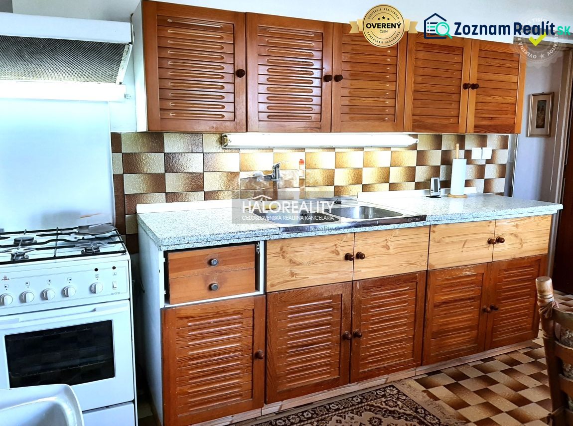 A kitchen in a family house with wooden cabinets and a stove, floor with wooden decor.