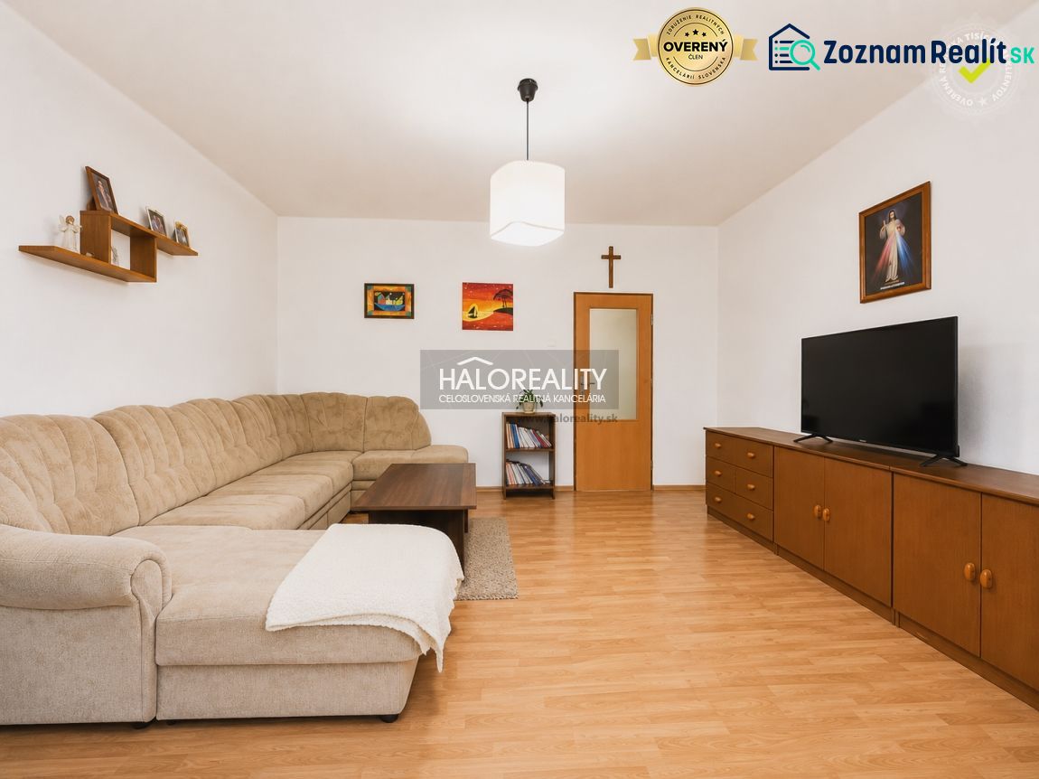 Living room with a corner sofa and a wooden decor floor in a family house.