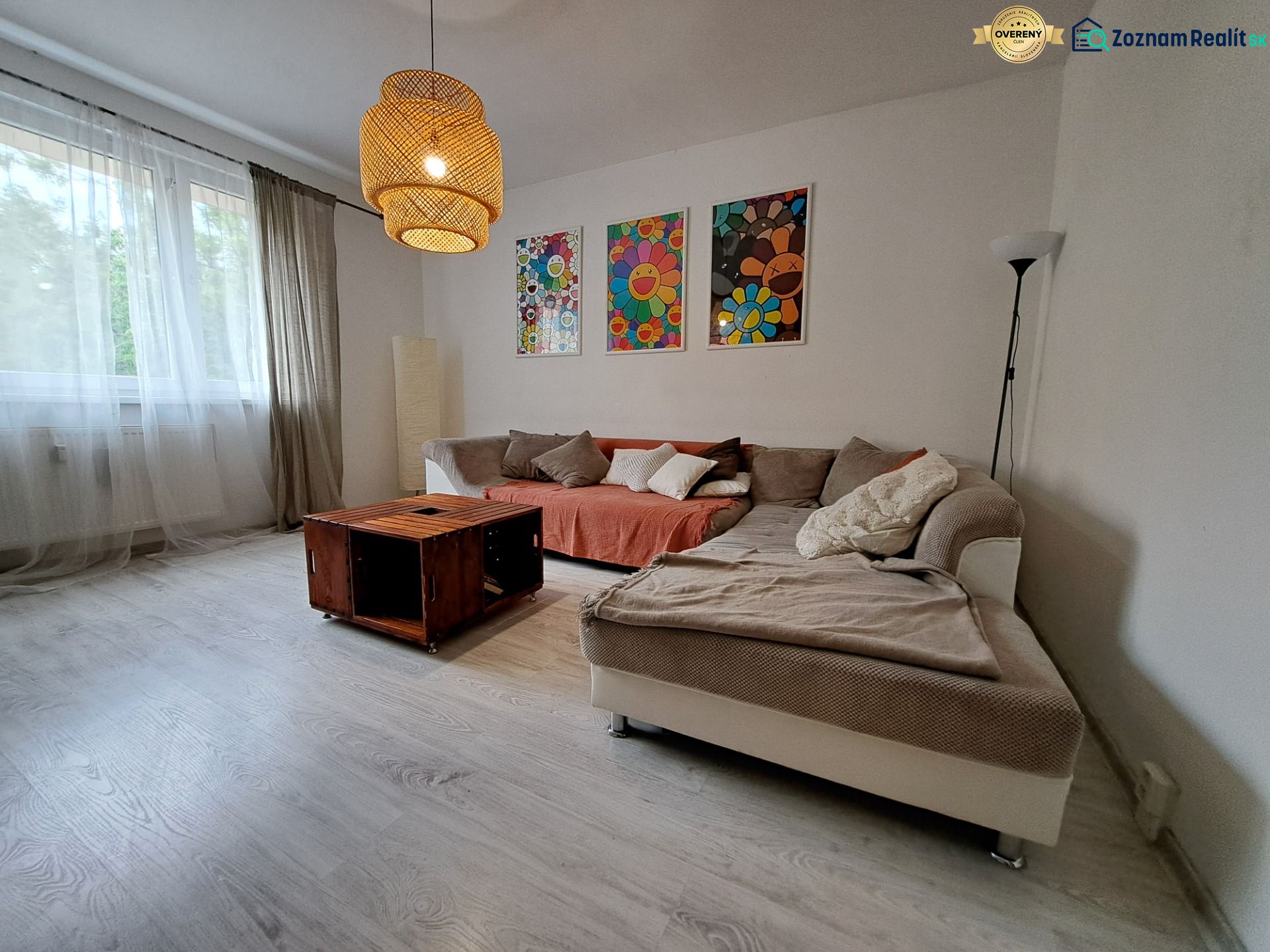 Living room in a 3-room apartment with a comfortable sofa and wooden decor flooring.