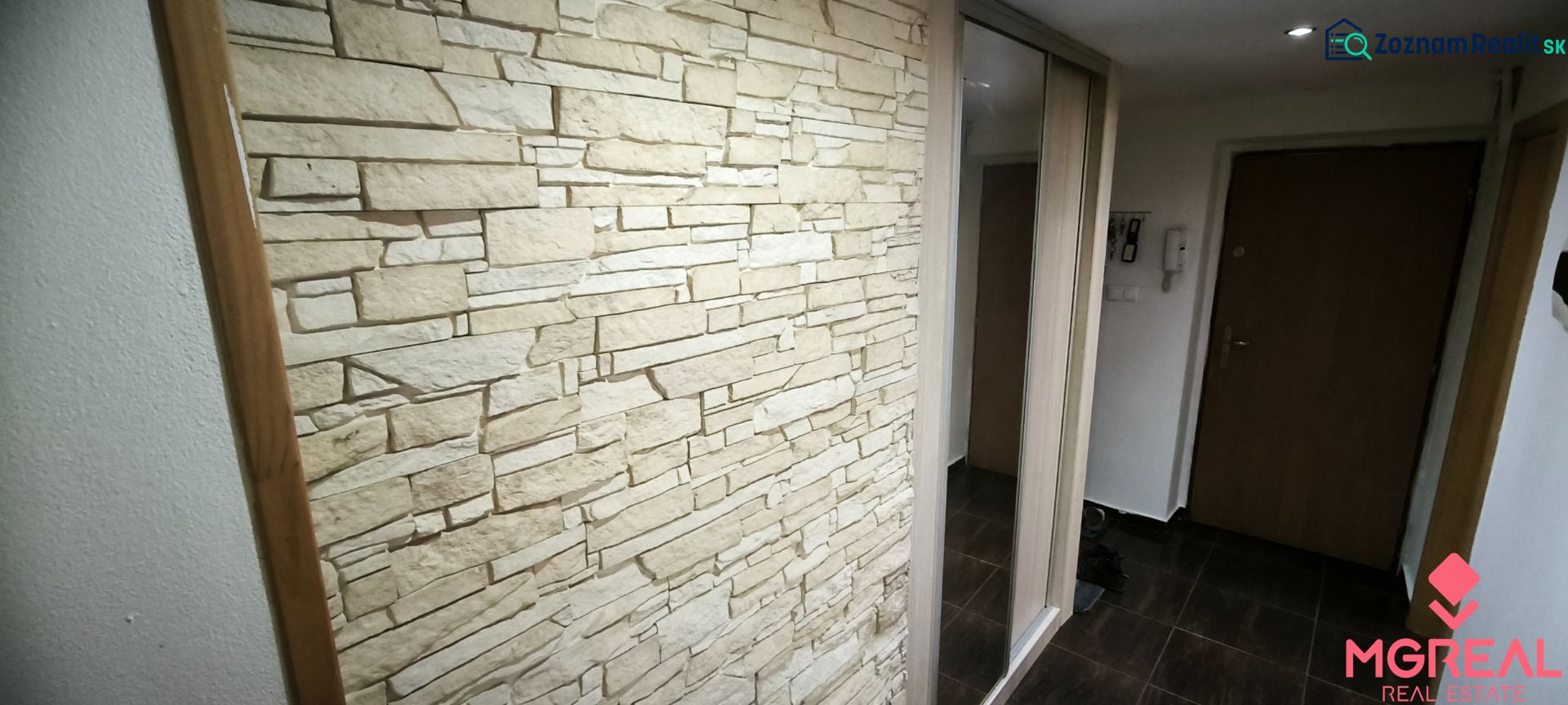 Stone cladding and mirrored doors in the entrance hallway of a 3-room apartment.