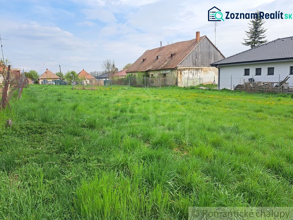 Family houses in Hruboňovo surrounded by green gardens and blue skies.