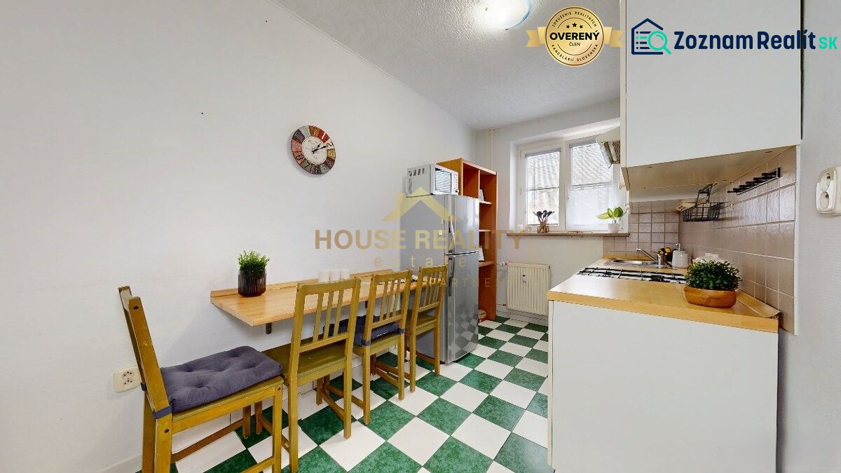 A kitchen in a studio apartment with a dining area, linoleum flooring, and appliances.