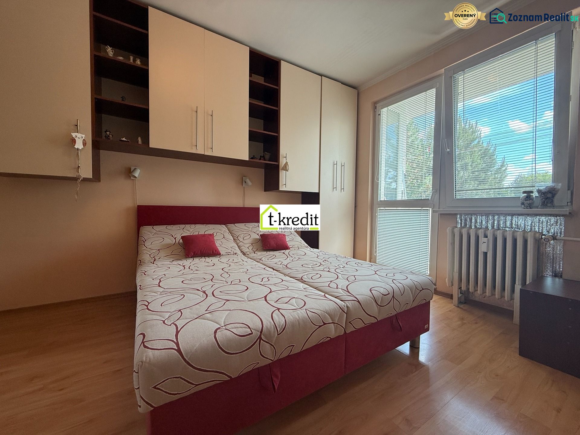 A room in a 3-room apartment with a bed, built-in wardrobes, and a floor with a wood decor.