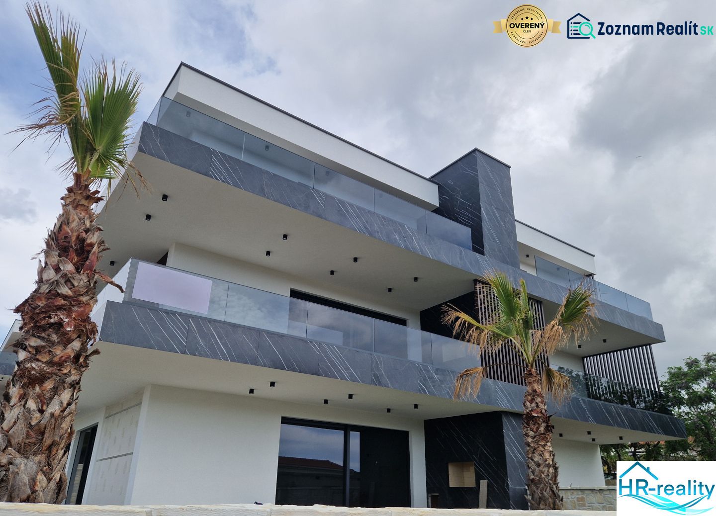 A recreational apartment in Stara Novalja with geometric architecture and palm trees against the backdrop of the sky.