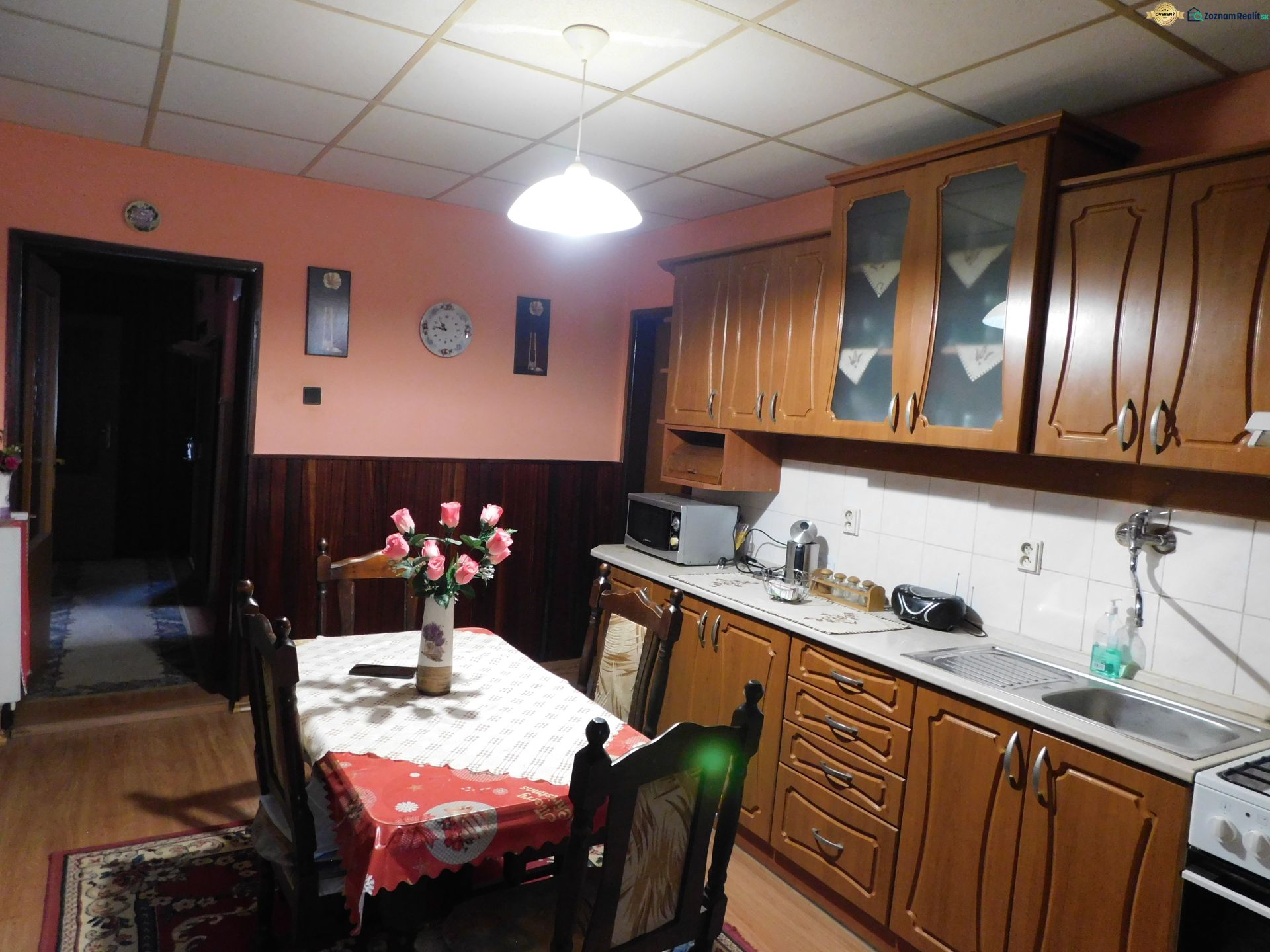 A kitchen with wooden decor, a dining table, and cabinets in a family house.