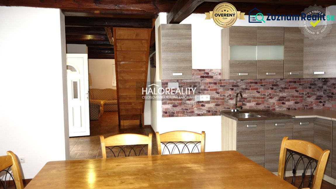 A kitchen with a wooden decor floor in a family house, wooden ceiling, brick wall cladding.