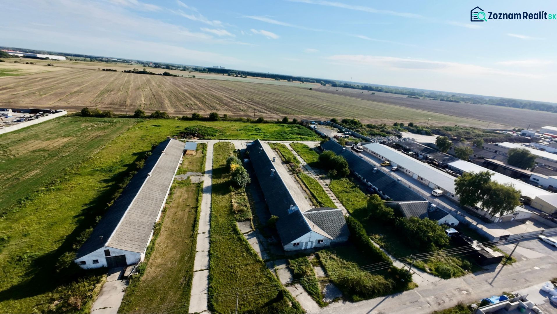 Production premises in Amadeho Kračany in Kostolné Kračany surrounded by agricultural fields.