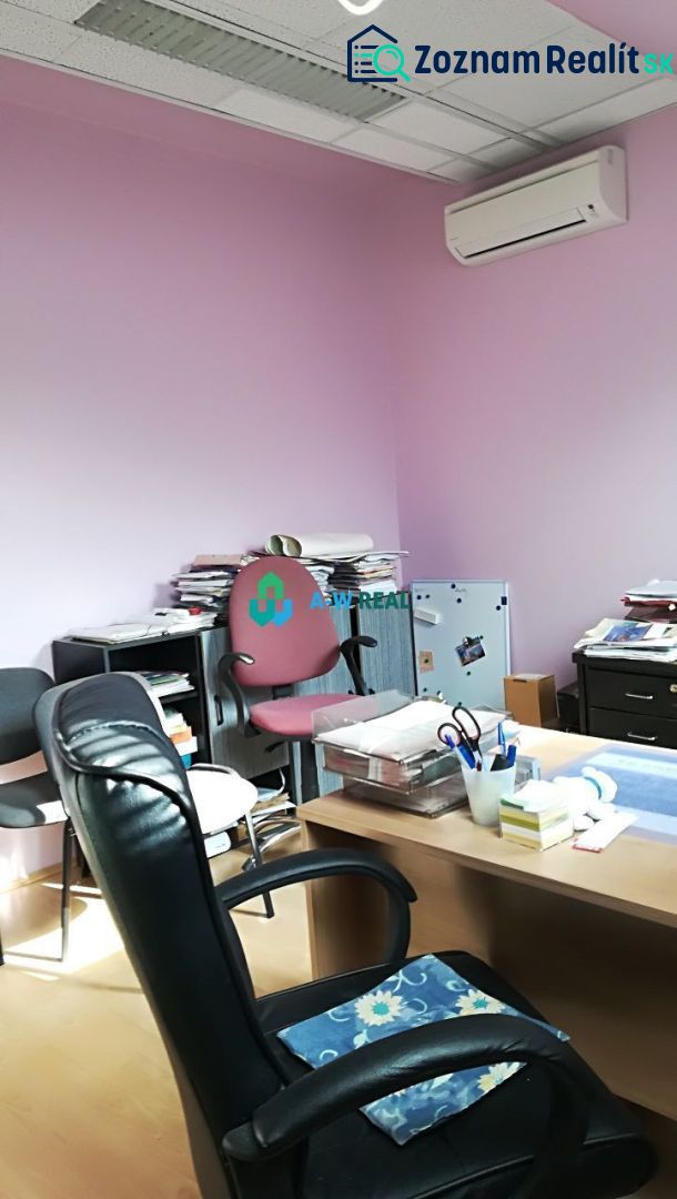 Offices with purple walls, a desk, and a wood-patterned floor.