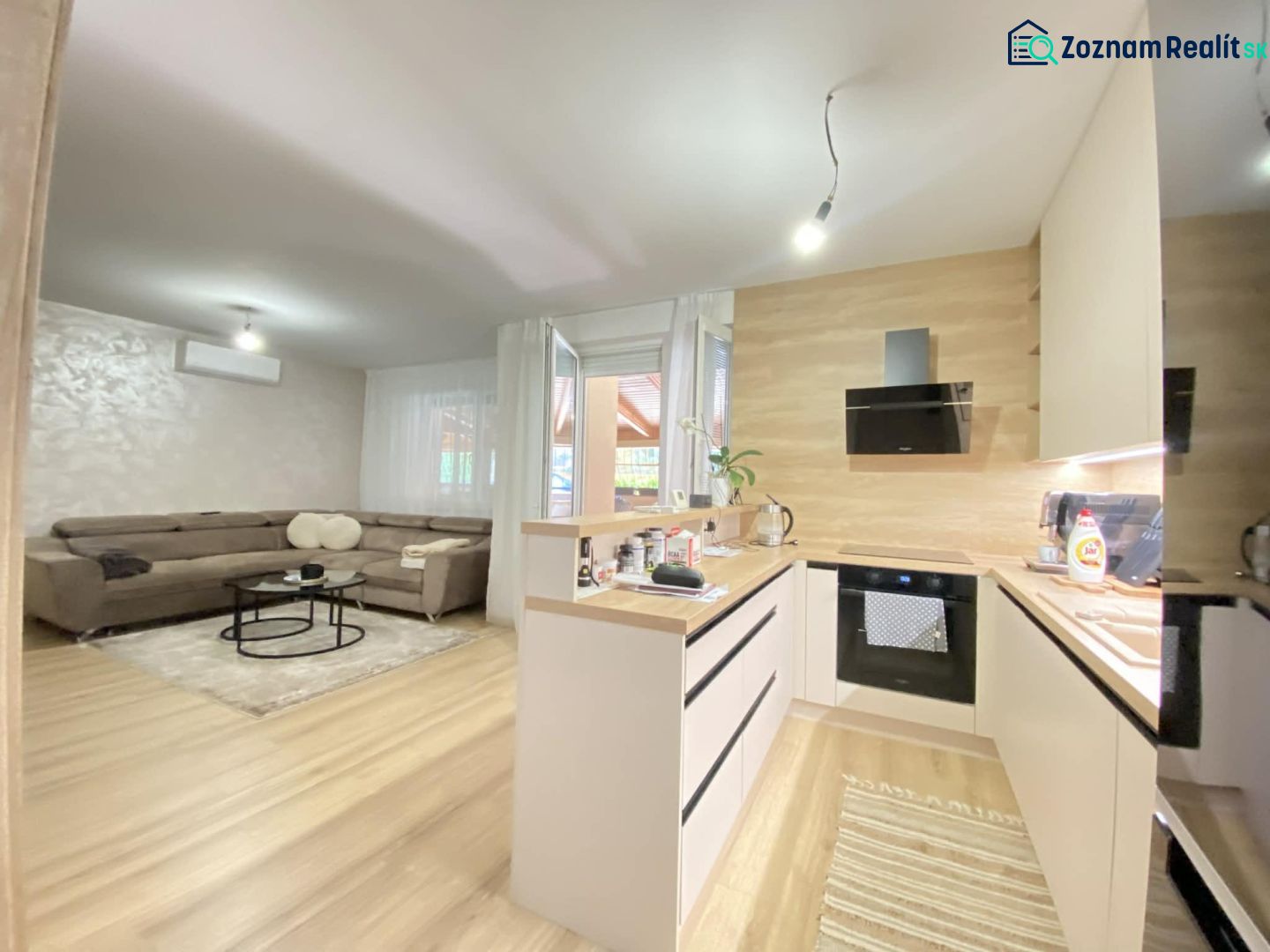 Kitchen and living room in a 3-room apartment with a wooden decor floor.