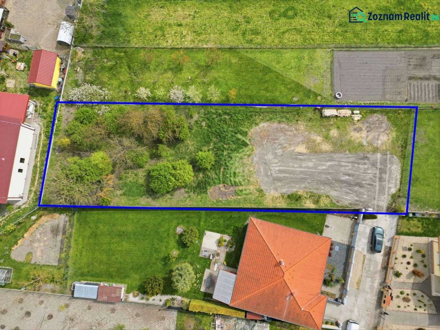 A grassy plot in Horná Potôň suitable for living, surrounded by neighboring plots and buildings.