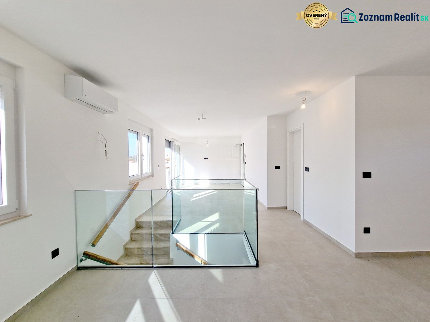 Interior of a 3-room apartment with glass railings and large windows.