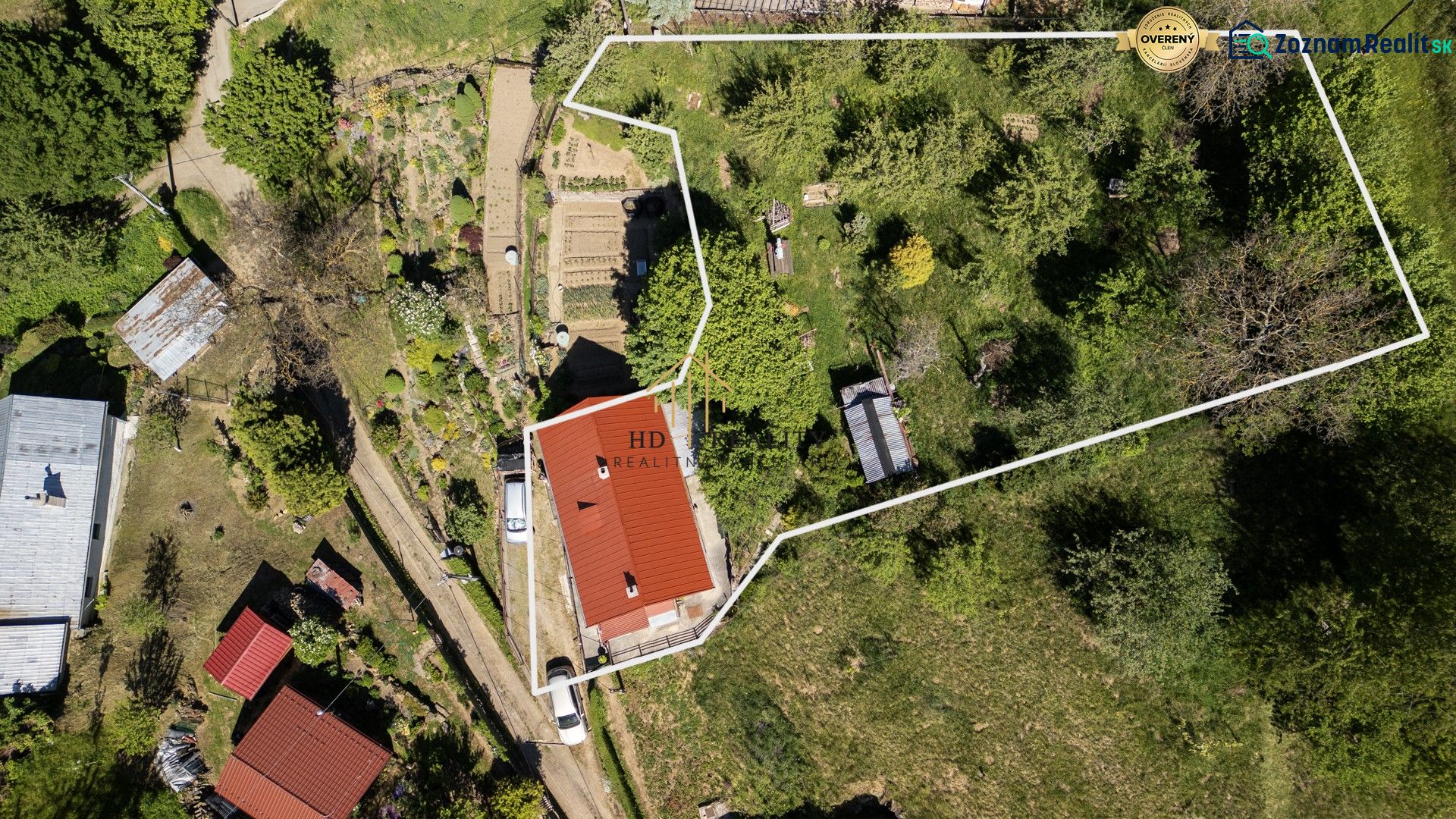 An aerial view of a family house in the town of Banky with an extensive garden and adjacent flower beds.
