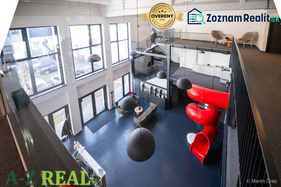 Office interiors with a slide, modern design, and large windows.